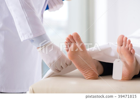 Police coroner examining dead body corpse in Police coroner examining dead body corpse in 39471815