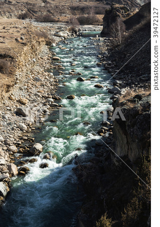 Stormy mountain river with stones splashes and 39472127