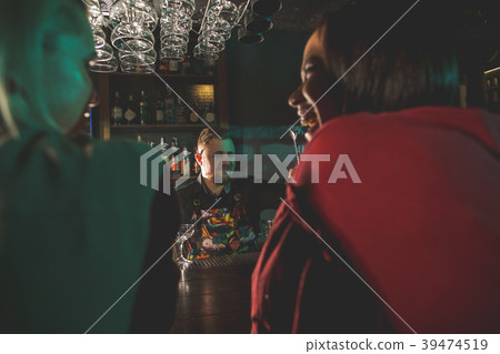 Cheerful barkeeper serving glad clients 39474519