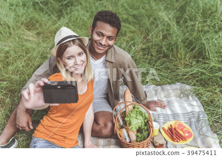 Pleased couple making selfie on picnic 39475411