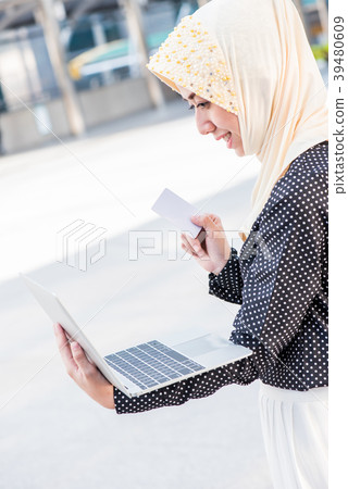 Muslim lady using card for online shopphing Muslim lady using card for online shopphing 39480609