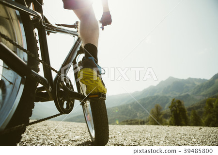 Toned photo of man in sneakers on bicycle at road Toned photo of man in sneakers on bicycle at road 39485800
