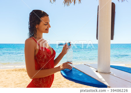 Happy young woman holding a water on the beach. Happy young woman holding a water on the beach. 39486226