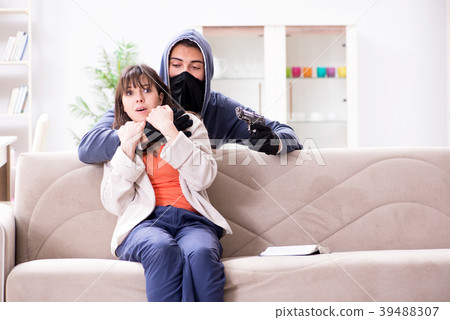 Armed man assaulting young woman at home 39488307