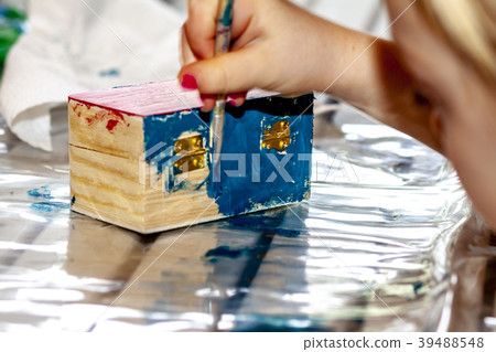 Little girl painting a wooden box Little girl painting a wooden box 39488548