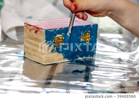 Little girl painting a wooden box Little girl painting a wooden box 39488560