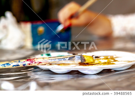 Little girl painting a wooden box Little girl painting a wooden box 39488565