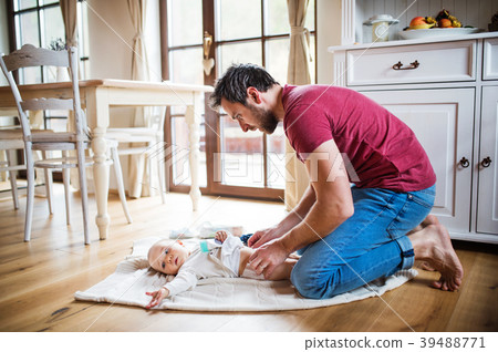 Father changing a baby girl at home. Father changing a baby girl at home. 39488771