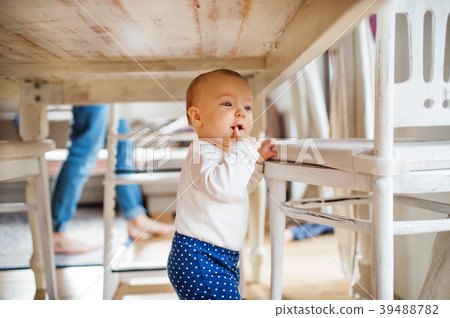 A baby girl under the table at home. A baby girl under the table at home. 39488782