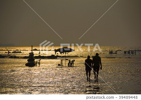 Silhouette with couple walking on Alibag beach Silhouette with couple walking on Alibag beach 39489448