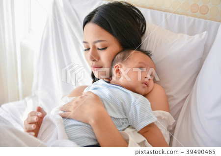 Newborn Concept. Mother and child on a white bed. Mom and baby b Newborn Concept. Mother and child on a white bed. Mom and baby b 39490465