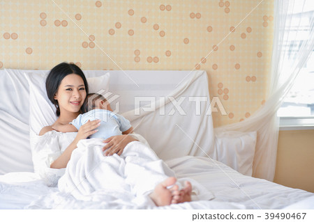 Newborn Concept. Mother and child on a white bed. Mom and baby b Newborn Concept. Mother and child on a white bed. Mom and baby b 39490467