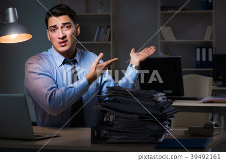 Employee working late at night at important report Employee working late at night at important report 39492161