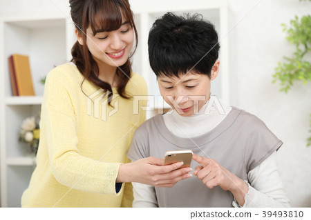 Mother who is taught how to use smartphone 39493810