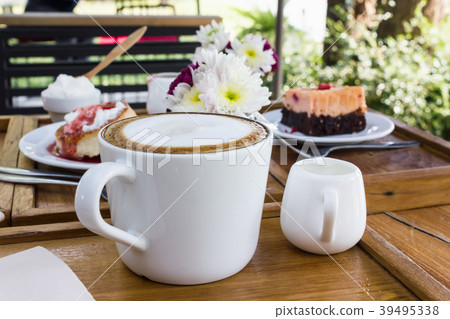 Hot coffee on wood table with cake background  39495338
