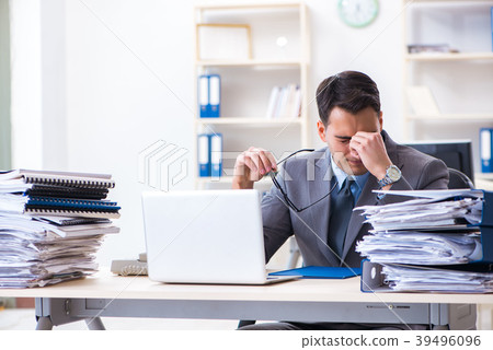 Overloaded with work employee under paperwork Overloaded with work employee under paperwork 39496096