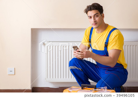 Young repairman contractor repairing heating panel Young repairman contractor repairing heating panel 39496105