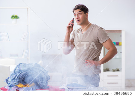 Inattentive husband burning clothing while ironing 39496690