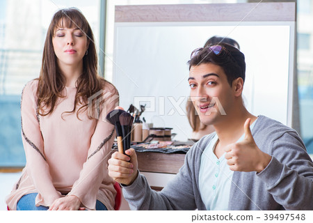 Man doing make-up for cute woman in beauty salon Man doing make-up for cute woman in beauty salon 39497548