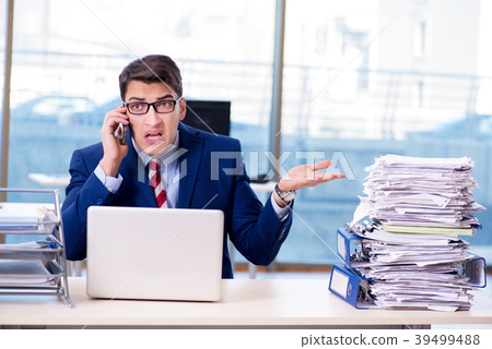 Businessman workaholic struggling with pile of 39499488