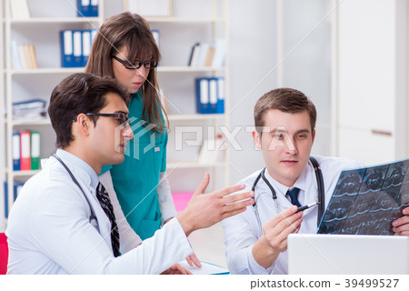 Three doctors discussing scan results of x-ray 39499527