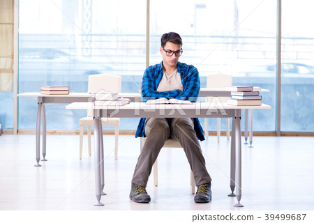 Student studying in the empty library with book 39499687