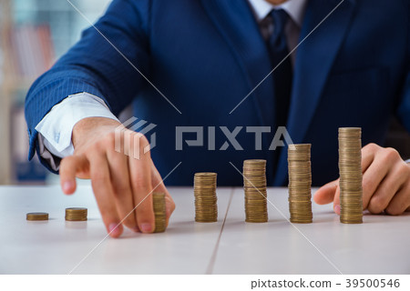 Businessman with stacks of coins in the office 39500546