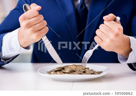 Funny businessman eating gold coins in office 39500662