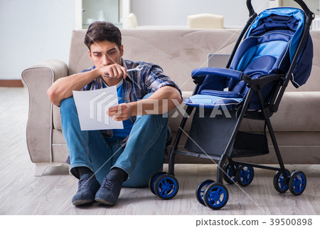 Young father assembling baby pram at home Young father assembling baby pram at home 39500898