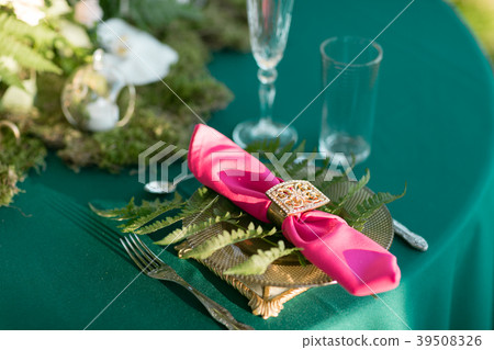 Pink napkin with a patterned clip. table setting Pink napkin with a patterned clip. table setting 39508326