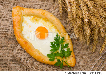 Open pie with cheese and eggs on sackcloth 39511948