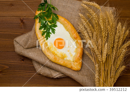 Khachapuri with egg and wheat ears on sacking 39512212