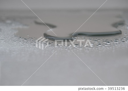 A small puddle of water with droplets  39513236