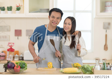 Portrait of happy young couple cooking together. 39517224