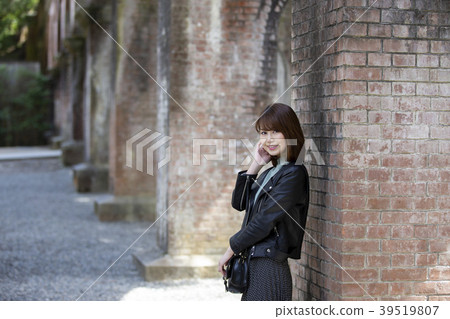 A smiling young woman behind a water channel in Nanzenji Temple in Sakyo Ward, Kyoto City, Kyoto Prefecture A smiling young woman behind a water channel in Nanzenji Temple in Sakyo Ward, Kyoto City, Kyoto Prefecture 39519807