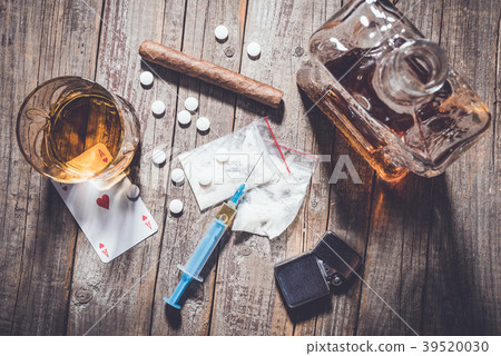 Hard drugs and alcohol on an old wooden table 39520030