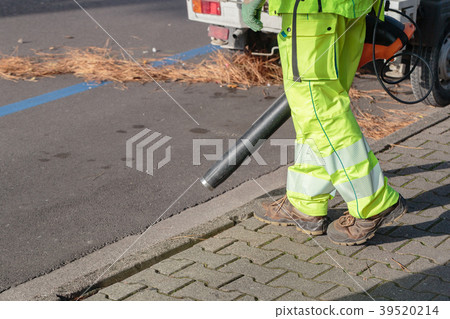 Landscaper worker cleaning foot way in park from 39520214