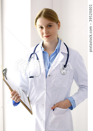 Female doctor filling up medical form on clipboard Female doctor filling up medical form on clipboard 39520801