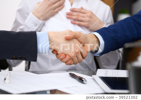 Business people shaking hands, finishing up a Business people shaking hands, finishing up a 39521302