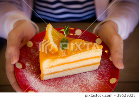 Tasty orange fruit cake on red christmas patt dish Tasty orange fruit cake on red christmas patt dish 39529325