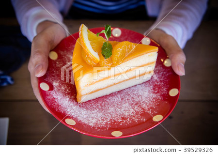 Tasty orange fruit cake on red christmas patt dish Tasty orange fruit cake on red christmas patt dish 39529326