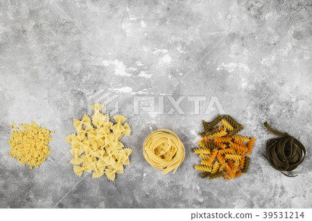 Various raw pasta on gray background. Top view Various raw pasta on gray background. Top view 39531214