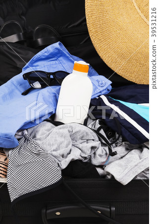 Open suitcase with clothes, sun protection lotion Open suitcase with clothes, sun protection lotion 39531216