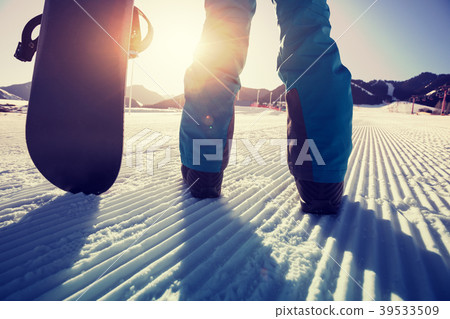 snowboarder with snowboard stand on ski piste  39533509