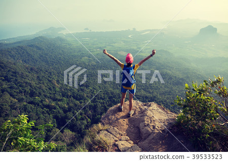 woman hiker enjoying the view on cliff edge woman hiker enjoying the view on cliff edge 39533523