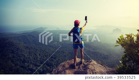 female hiker taking photo stand on cliff edge female hiker taking photo stand on cliff edge 39533525