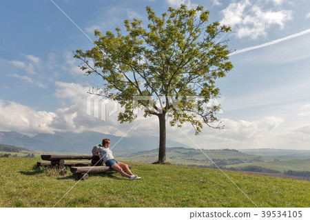 Woman sitting on summer hill Woman sitting on summer hill 39534105