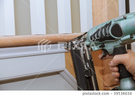 Carpenter brad using nail gun to Moulding trim, 39536038