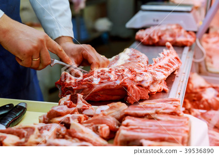 male butcher cutting raw meat with knife 39536890