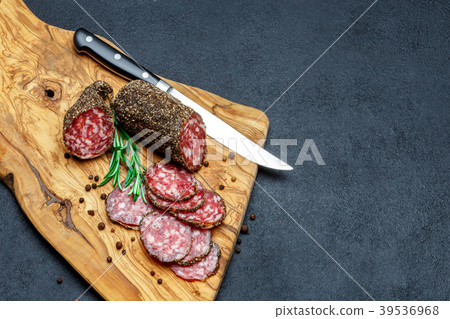 Dried organic salami sausage on wooden cutting Dried organic salami sausage on wooden cutting 39536968